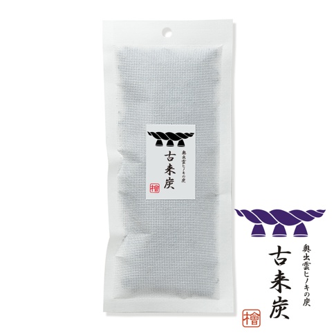 這是一包裝在白色網狀袋中的古來炭木炭商品，包裝中央貼有白色標籤，上方繪有紫色的注連繩圖案，標籤文字為古來炭以及奧出雲檜木炭，並配有一個印有檜字的紅色方形圖章。