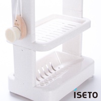 米白色塑膠三層浴室收納架，帶有排水孔的托盤，左側掛有木質手柄的清潔刷。