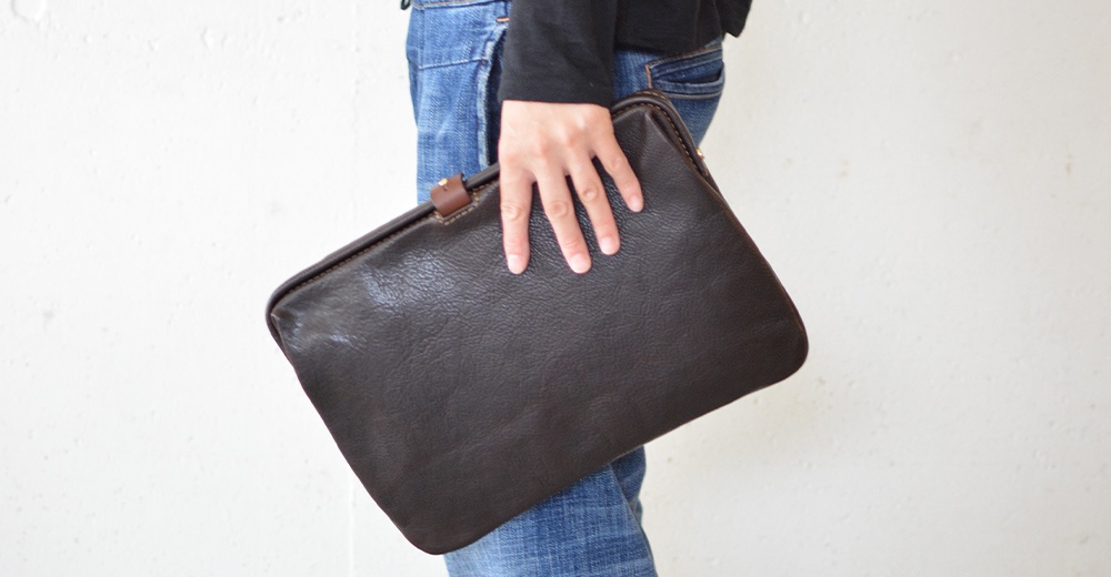 職人手作皮革Organ手拿包，深棕色，觸感細膩的皮革材質，簡潔大方的設計，搭配牛仔褲，適合日常攜帶。