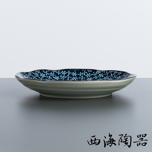 日本美濃燒輕量雅菊五件式大圓盤，盤面為深藍色底，飾以白色小花圖案，盤緣呈波浪狀，盤身則為淺灰色，帶有細緻的紋路。