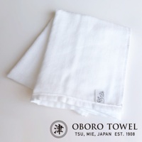 白色三層紗專身潔膚巾，織紋細緻，材質柔軟，一角有品牌商標與可愛的嬰兒圖案標籤。