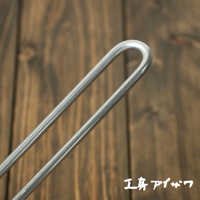 不鏽鋼雙口牛奶鍋的鍋柄，呈現金屬銀色，採用圓弧形設計，材質為不鏽鋼。