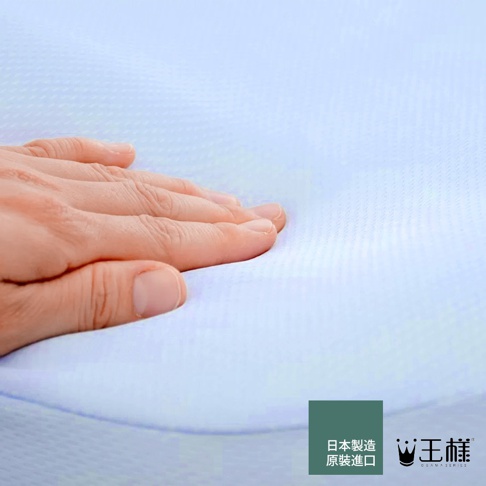 手輕壓在淺藍色、帶有細微菱形紋理的枕頭表面，展現其柔軟觸感。