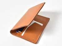 職人手作皮革多用途收納長夾，採用天然棕色皮革製成，車縫線清晰。長夾內層有卡片夾層，可收納護照、卡片及紙張等物品。