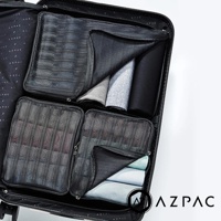 AZPAC 黑色旅行收納袋組，內含多個網狀收納袋，整齊擺放於行李箱內，部分收納袋內裝有衣物。