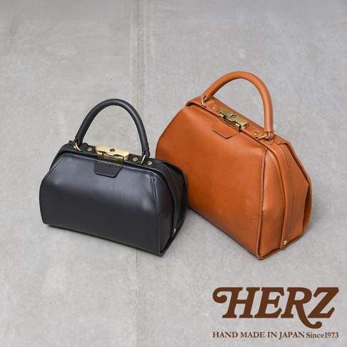 兩款職人手作皮革Organ兩用口金手提包，一款為黑色，另一款為棕色。兩款包皆為皮革材質，擁有金色口金鎖扣和圓形提把，設計簡潔大方。