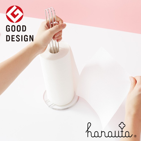 銀色不鏽鋼製的立式紙巾架，架上裝有白色紙巾捲，一隻手正在拉扯紙巾。