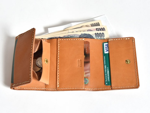 職人手作皮革三折式迷你短夾，淺棕色皮革，內有日圓紙鈔、硬幣、信用卡及其他卡片，縫線清晰。