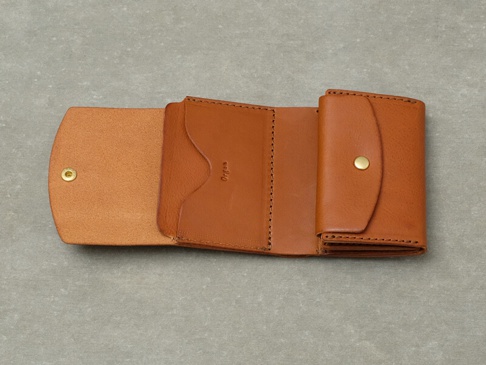 職人手作Organ迷你短夾，棕褐色皮革製成，附有金屬按扣，內部結構清晰可見，呈現其簡潔實用的設計。