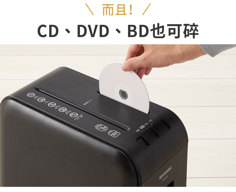 黑色塑膠碎紙機，頂部有一個專用投遞口，手正將一張白色 CD 放入投遞口，碎紙機面板上有指示燈和操作按鈕，顯示「IRIS OHYAMA P6HCS」字樣。