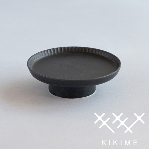 koudai 美濃燒高腳平盤，黑色，陶瓷材質，盤面有放射狀紋路，盤緣帶有細緻刻紋，整體呈現樸實質感。