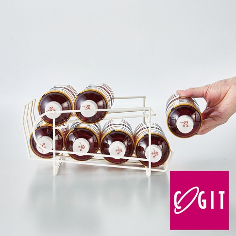 白色金屬製成的滾動式寶特瓶收納架，可容納七瓶紅色液體寶特瓶，其中一瓶正由手取出。