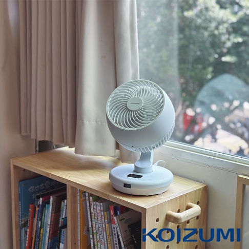 白色鵝頸颶風智能循環扇，風扇頭為圓形，設有網狀扇葉，底座為圓形，有觸控按鈕和顯示螢幕，擺放在木製置物架上，背景為淺色窗簾和窗外風景。