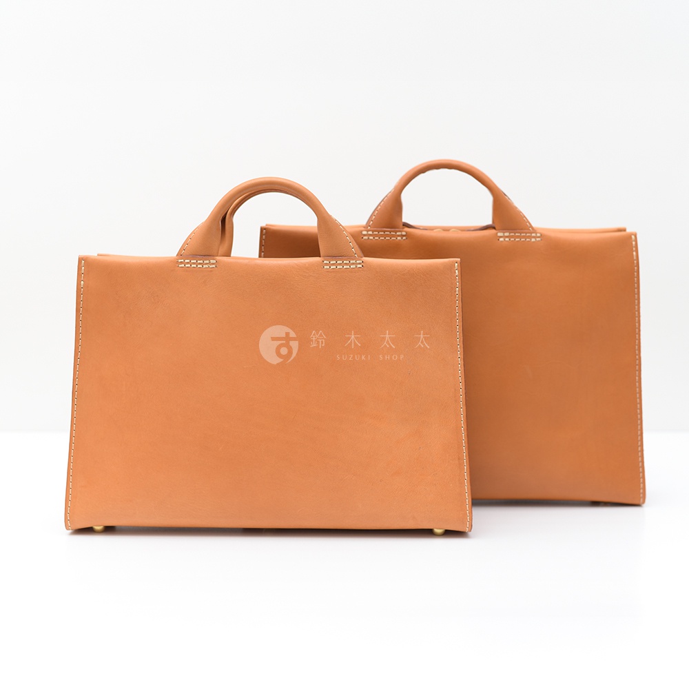 以日本HERZ品牌為名的雙色調皮革公事包，一個較大，一個較小，上方均有提把，大包正面印有SUZUKI SHOP的日文與英文商標