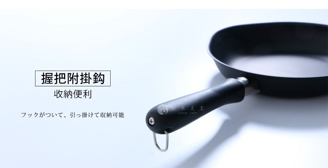 這是一支黑色的鐵鍋手柄特寫，手柄末端設有一個金屬掛鉤，方便懸掛收納，圖片左側標示有握把附掛鉤與收納便利等說明文字。