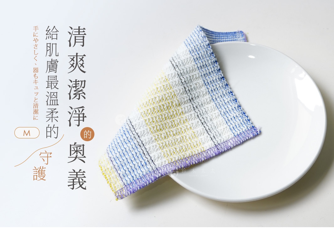 一條橘黃色、藍色和白色格紋的壓克力纖維清潔巾，疊放在白色盤子上。