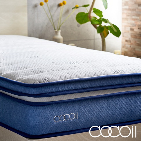 白色紋理床墊，側面為藍色織物材質，帶有白色「cocoil」品牌標誌，床墊頂部有「SKIN」字樣壓紋，雙人尺寸。