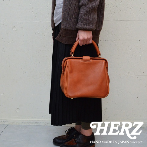 職人手作皮革Organ方形口金托特包，經典方形設計，採用鞣製皮革材質，搭配金色金屬扣環，呈現溫潤的焦糖棕色調，質感精緻，款式大方。