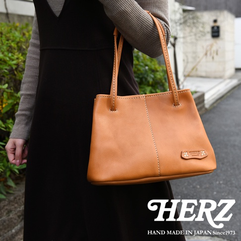 日本HERZ手工皮革托特包，焦糖色，簡約設計，附有品牌Logo。