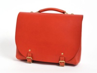 橘紅色皮革製成的職人手作雙扣兩用側背包，具有提把、可調節長度的肩帶連接環，以及兩個金屬釦環和鉚釘，風格簡約。