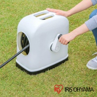 白色全覆蓋水管車，帶有黑色底座和白色捲線把手，左側有一個圓形開口，露出部分黑色水管。產品置於草地上，一雙手放在水管車頂部，另一隻手正轉動把手。