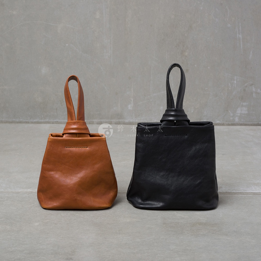 兩款皮革手提包，一款為棕色，另一款為黑色，皆為單柄設計，手柄處有扭結造型，包身為方形，線條簡約。