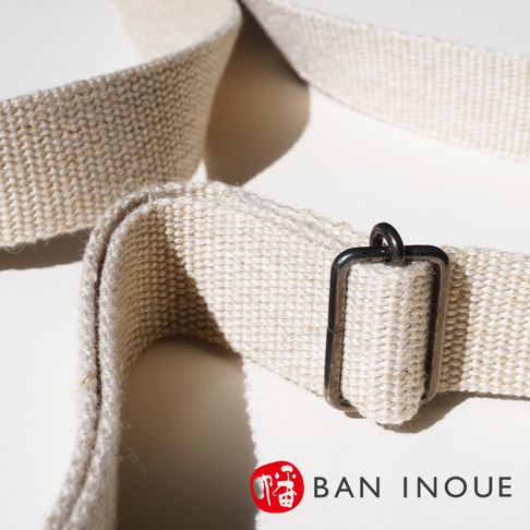 BAN INOUE 蚊帳棉裂織手提袋，特寫帆布材質的提把與金屬扣環，品牌 Logo 標示於右下角