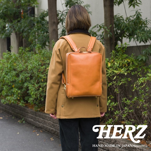職人手作皮革軟皮商務後背包 R-28，採用天然皮革製成，呈現溫潤的焦糖棕色，設計簡約方正，適合商務場合。