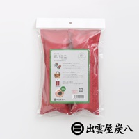 一組兩入的紅色鞋靴專用調濕木炭，包裝上印有日文說明及產品細節，材質為透氣布料，內部可見黑色顆粒狀木炭。