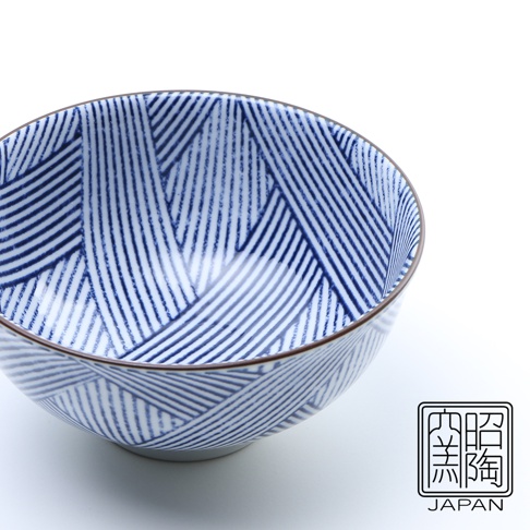 藍染縞格子飯碗，陶瓷材質，碗身內外皆飾有深藍色線條組成的幾何縞格子圖案，碗口邊緣為細棕色線條，碗底為白色。