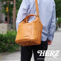 職人手作皮革厚實單肩波士頓包，採用淺棕色皮革，搭配白色縫線及金色五金配件，包款設計簡潔，容量充足。