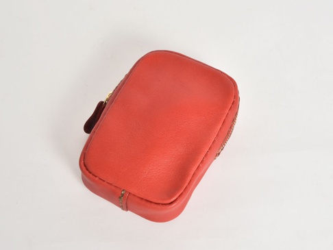 紅色皮革菸盒收納包，拉鍊開合，附有深棕色皮革拉片。