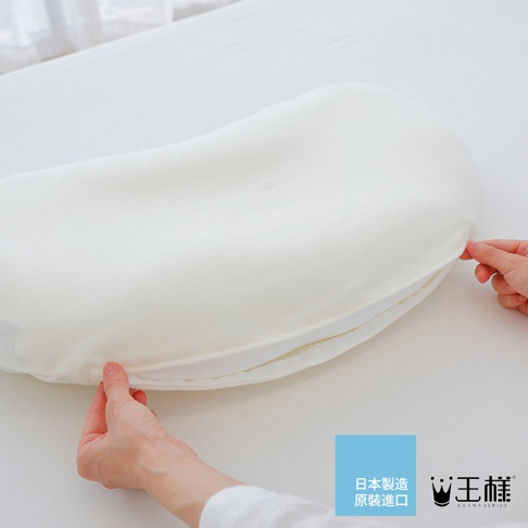 王樣の雲上枕專用枕套，材質柔軟，呈現米白色，展示了雙手將枕套套入枕頭的過程。