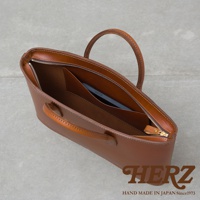 職人手作棕色皮革薄型公事包，設有拉鍊開合及內袋，配有提把。