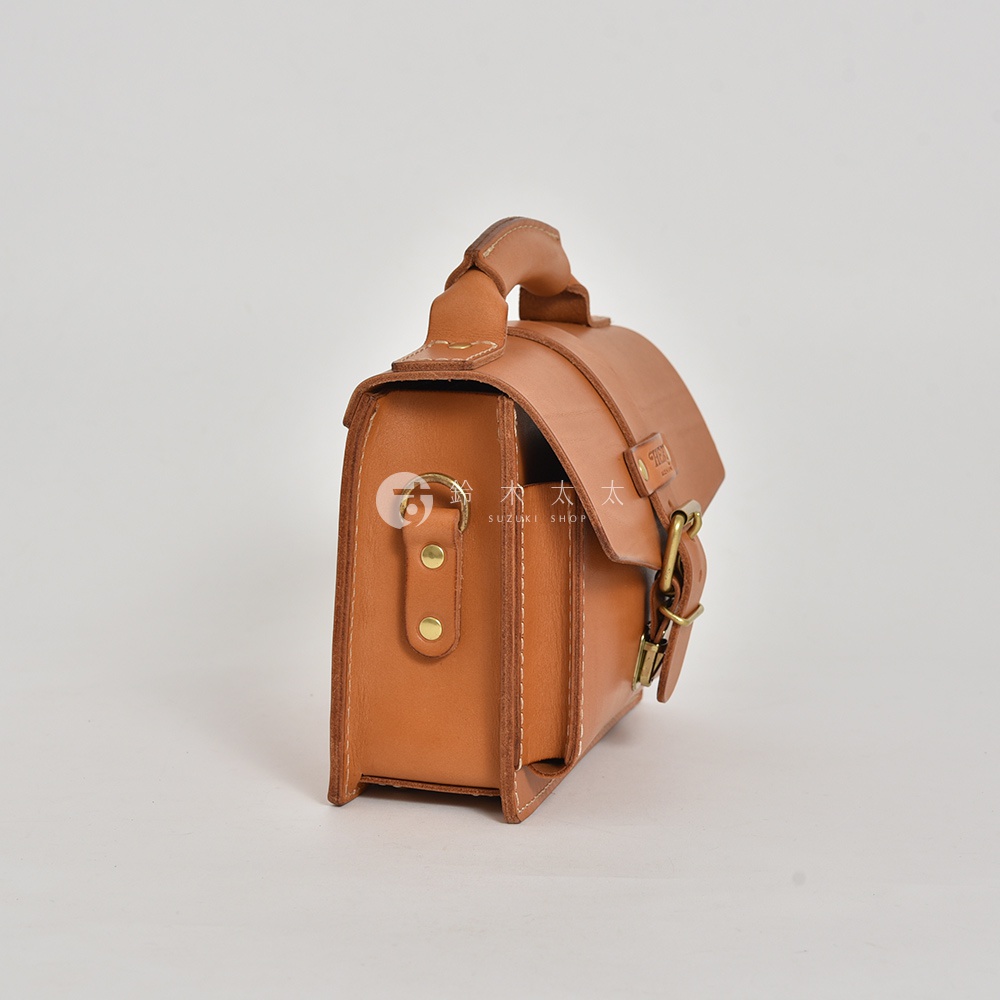 職人手作皮革經典混合風迷你單肩包，採用淺棕色皮革製成，帶有金屬扣環和縫線細節，設計簡約有質感。