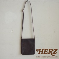 深棕色皮革製成的職人手作Organ肩背小方包，包身線條簡潔，搭配細長可調式肩帶，正面無多餘裝飾，展現皮革的自然紋理。