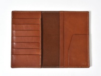 職人手作皮革多用途收納長夾，淺棕色皮革，攤開內裡，左側有六個卡槽，右側有兩個直插式夾層，內部為深棕色皮革，右下角壓印品牌標誌。