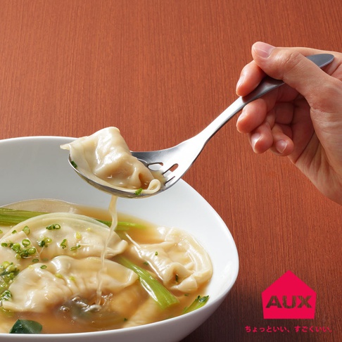 銀色金屬濾水菜匙，湯匙頭有長條形濾孔，正從白色湯碗中撈起一顆飽滿的餛飩，湯汁從濾孔滴落。