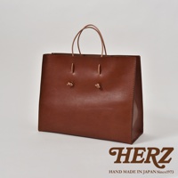 棕色皮革手提袋，簡約方形設計，配有兩條細皮革提把，正面中央有兩個皮革綁結裝飾。