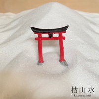 日本枯山水模型，紅色鳥居，黑色屋頂，底部有銀色細節，立於細緻的白色砂石中。