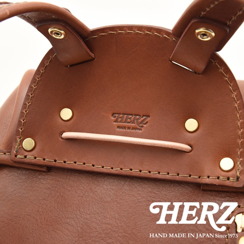 職人手作皮革經典雙扣後背包，深棕色皮革，帶有品牌壓紋及五金扣件。