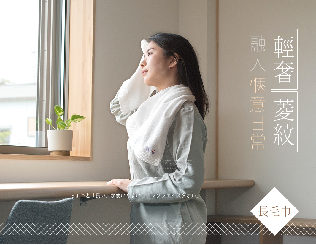 一位女性正用一條白色純棉長毛巾擦拭額頭，毛巾上有精緻的菱紋織紋，散發出今治純棉的質感。