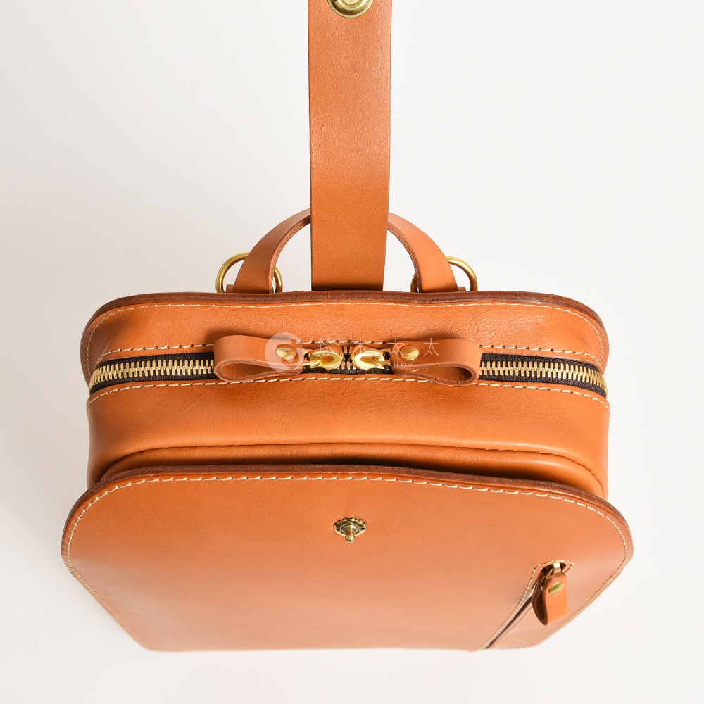 棕色皮革製成的職人手作兩用後背包，具有雙拉鍊主袋、前方翻蓋口袋和可調節肩帶。