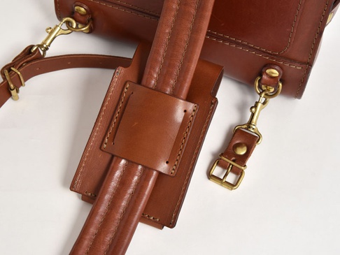 職人手作皮革三用手機收納包 (KM-1) S，呈現經典棕色，材質為真皮，包身結構穩固，配有金屬扣環及可拆卸的皮質背帶。