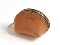 淺棕色職人手作皮革貝殼造型零錢包，配有黃銅色拉鍊和縫線，正面壓印有「HERZ」及「MADE IN JAPAN」字樣。