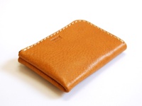 職人手作皮革L型拉鍊軟皮卡片收納夾，焦糖棕色，表面呈現自然紋理，邊緣以白色縫線手工縫製。