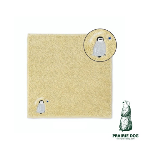 淺黃色毛巾，一角繡有灰色企鵝與藍色星星圖案，並附有放大圖示。右下角有草原犬鼠插畫及品牌名稱 PRAIRIE DOG。