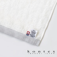 今治純棉浴巾，白色主體，帶有灰色細條紋邊緣，材質標籤標示為「Cotton 100% Made in Japan」。