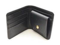 職人手作黑色皮革經典掀蓋扣式雙折短夾，內有四個卡槽與一個帶有黃銅釦的零錢袋。