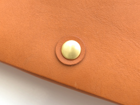 職人手作皮革旅行用護照機票收納長夾，採用溫暖的棕褐色皮革，搭配一顆圓形金色金屬按扣，設計簡潔實用。